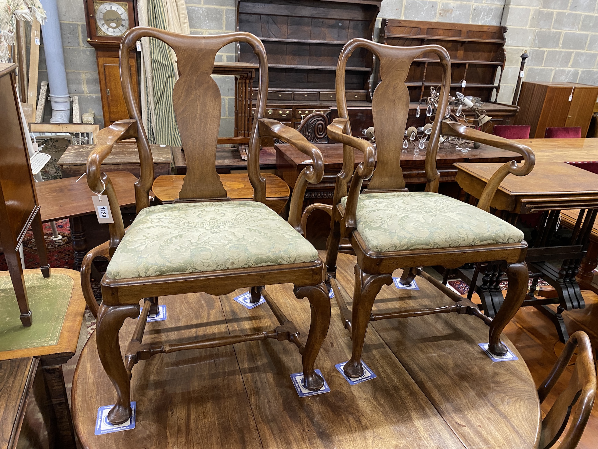 A set of four George I walnut dining chairs and two later matching elbow chairs with upholstered drop in seats on cabriole front legs.